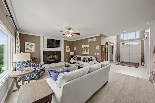 7007 Bell Rd, Shawnee, KS 66217 - carpeted living area featuring plenty of natural light, crown molding, ceiling fan, a fireplace, and tile patterned flooring