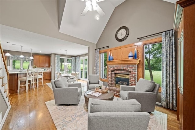 7007 Bell Rd, Shawnee, KS 66217 - living area featuring a brick fireplace, plenty of natural light, light wood-style floors, high vaulted ceiling, and a ceiling fan