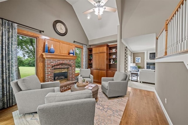 7007 Bell Rd, Shawnee, KS 66217 - living room with a brick fireplace, high vaulted ceiling, light wood finished floors, ceiling fan, and baseboards