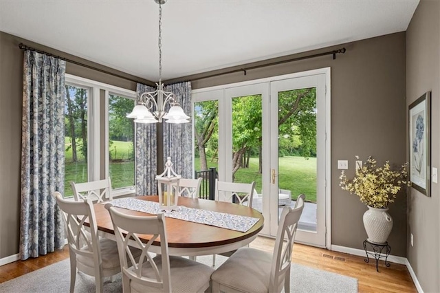 7007 Bell Rd, Shawnee, KS 66217 - dining area with a chandelier, light wood-style floors, and baseboards