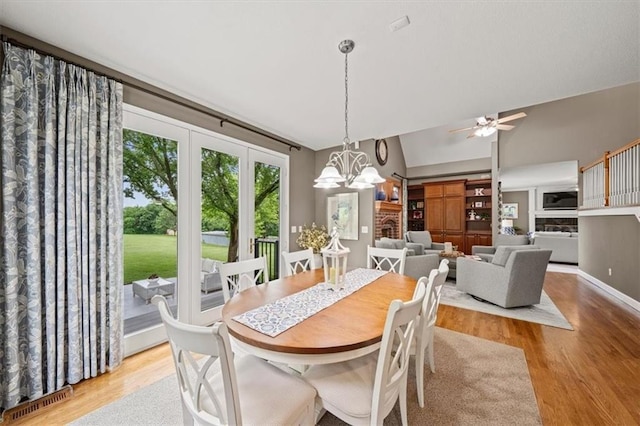 7007 Bell Rd, Shawnee, KS 66217 - dining area with wood finished floors, a chandelier, vaulted ceiling, and a ceiling fan