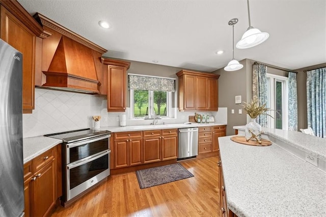 7007 Bell Rd, Shawnee, KS 66217 - kitchen with appliances with stainless steel finishes, custom exhaust hood, brown cabinets, light countertops, and recessed lighting