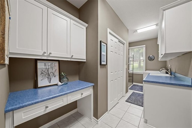 7007 Bell Rd, Shawnee, KS 66217 - laundry area with light tile patterned flooring, a sink, baseboards, and an office area