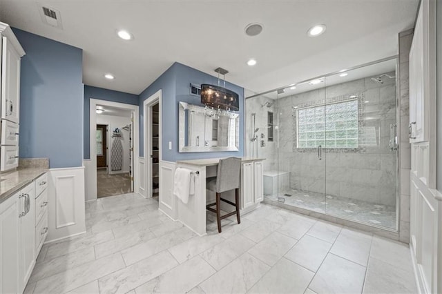 7007 Bell Rd, Shawnee, KS 66217 - full bath with vanity, a stall shower, a wainscoted wall, a spacious closet, and a decorative wall