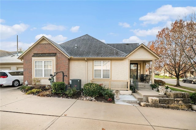 15141 S Symphony Dr Unit 1300, Olathe, KS 66062 - view of front facade with central AC unit, covered porch, roof with shingles, and stucco siding