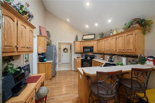 15141 S Symphony Dr Unit 1300, Olathe, KS 66062 - kitchen with black appliances, a sink, light countertops, a peninsula, and high vaulted ceiling