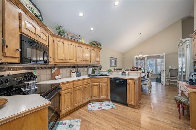 15141 S Symphony Dr Unit 1300, Olathe, KS 66062 - kitchen featuring black appliances, a sink, a peninsula, light wood-style flooring, and high vaulted ceiling