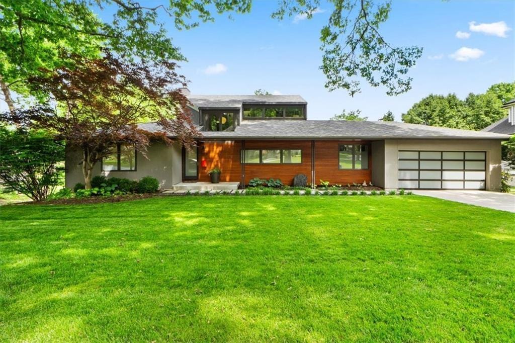 8308 Meadow Ln, Leawood, KS 66206 - view of front facade with a garage, a front lawn, driveway, and stucco siding