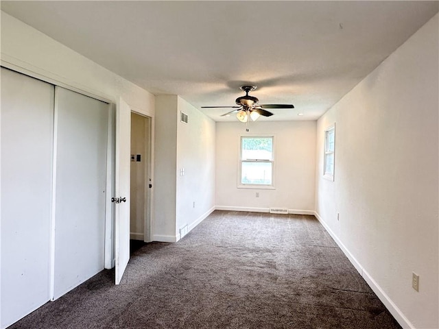 609 N Broadway St, Knob Noster, MO 65336 - unfurnished bedroom with dark carpet, a ceiling fan, a closet, and baseboards