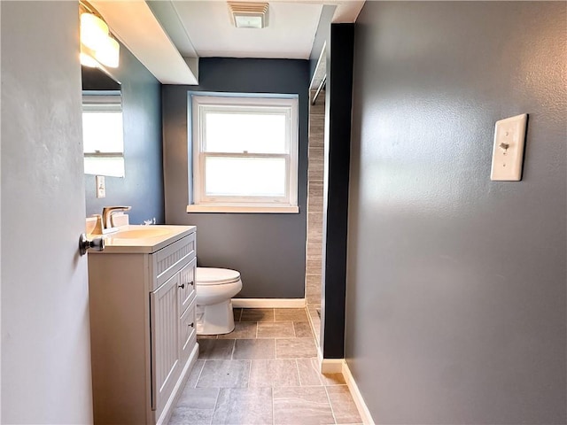 609 N Broadway St, Knob Noster, MO 65336 - full bath with vanity, baseboards, toilet, and stone tile flooring