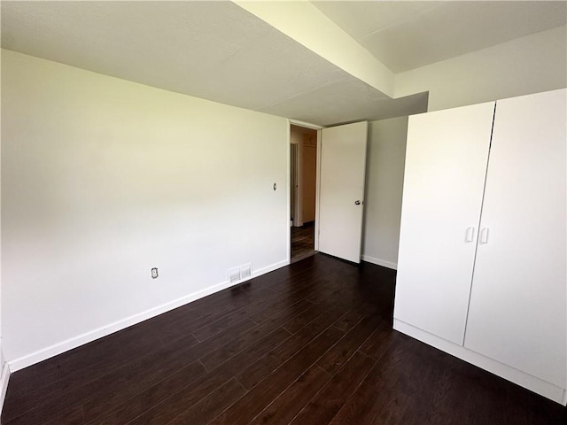 609 N Broadway St, Knob Noster, MO 65336 - unfurnished bedroom with dark wood finished floors and baseboards