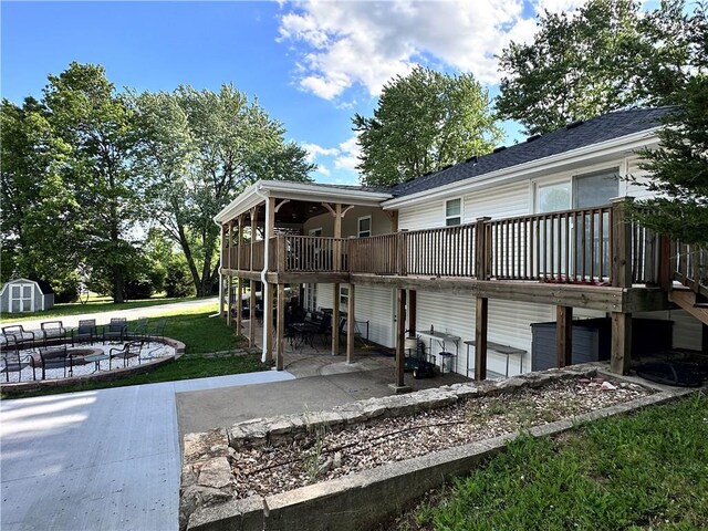 14409 Tillman Rd, Smithville, MO 64089 - rear view of property featuring a patio area, a lawn, a wooden deck, and an outdoor fire pit