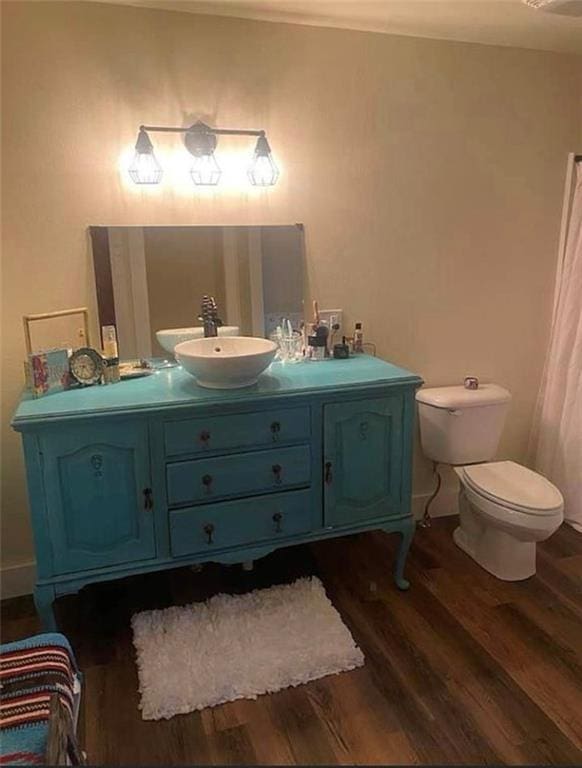 1596 Haskell Rd, Williamsburg, KS 66095 - bathroom featuring wood finished floors, vanity, toilet, and baseboards