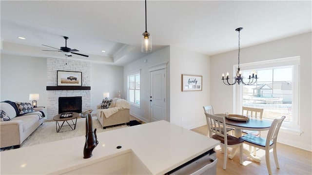 15595 N Sheridan Ct, Basehor, KS 66007 - living area with a large fireplace, a chandelier, light wood-style flooring, baseboards, and ceiling fan