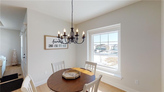 15595 N Sheridan Ct, Basehor, KS 66007 - dining area with a chandelier, light wood-style floors, and baseboards