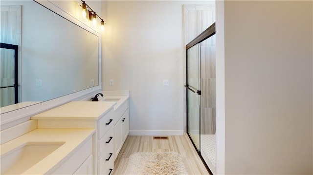 15595 N Sheridan Ct, Basehor, KS 66007 - full bath with vanity, a shower with shower door, baseboards, and wood finished floors