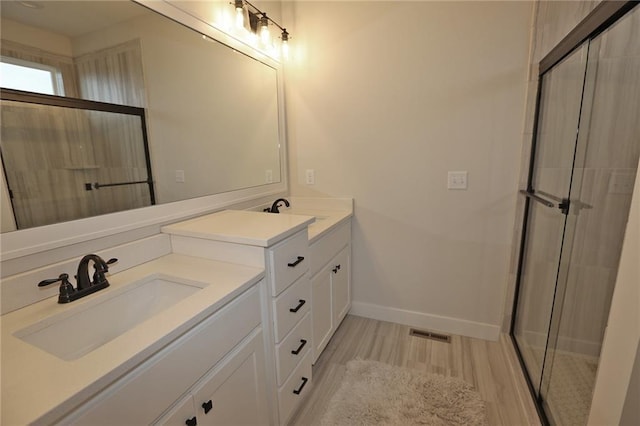 15595 N Sheridan Ct, Basehor, KS 66007 - bathroom featuring vanity, wood finished floors, baseboards, and an enclosed shower