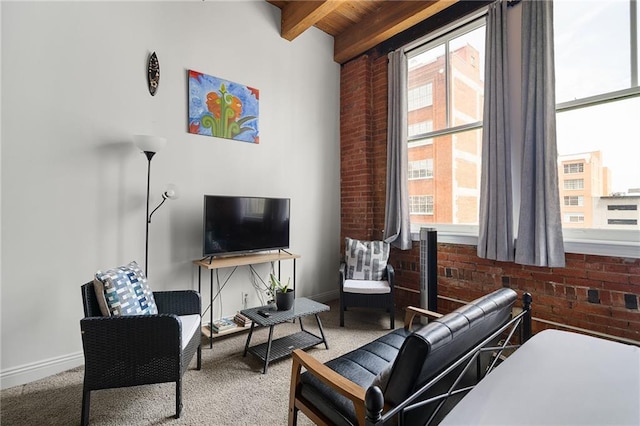 700 Broadway Blvd Unit 210, Kansas City, MO 64105 - carpeted living room with brick wall, plenty of natural light, baseboards, and wood ceiling with exposed beams