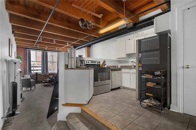 700 Broadway Blvd Unit 210, Kansas City, MO 64105 - kitchen featuring stainless steel appliances, wooden ceiling with exposed beams, white cabinets, dark countertops, and light tile patterned floors