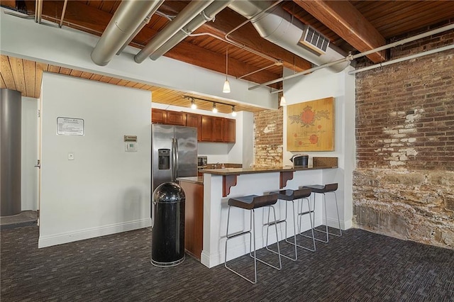 700 Broadway Blvd Unit 210, Kansas City, MO 64105 - kitchen featuring dark carpet, stainless steel fridge with ice dispenser, a peninsula, dark countertops, and a breakfast bar