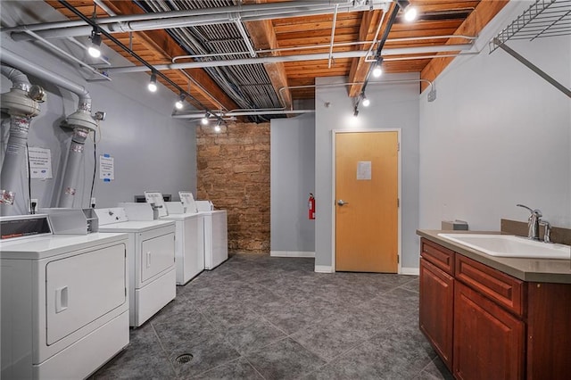 700 Broadway Blvd Unit 210, Kansas City, MO 64105 - laundry room featuring washing machine and dryer, a sink, track lighting, and baseboards