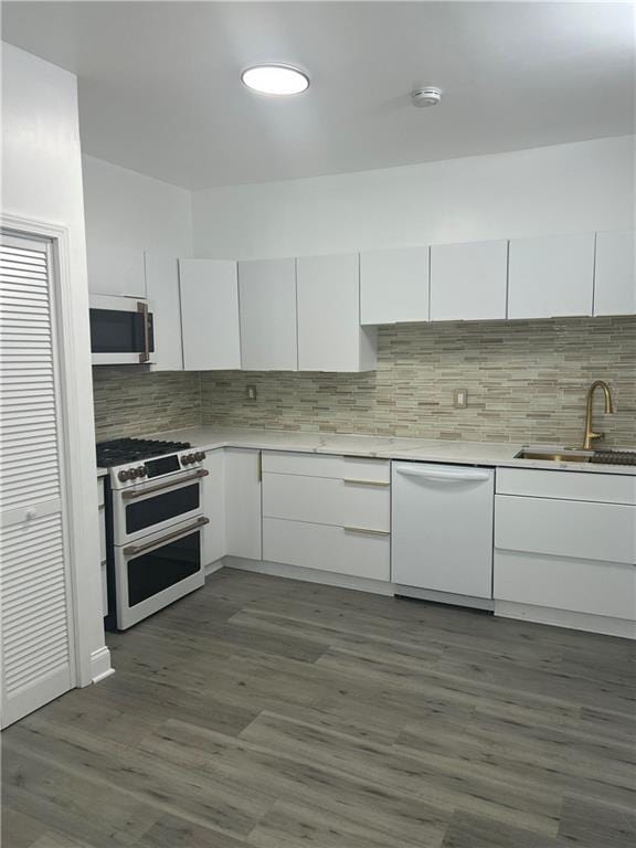 2831 E 8th St, Kansas City, MO 64124 - kitchen featuring white appliances, a sink, white cabinets, backsplash, and light countertops