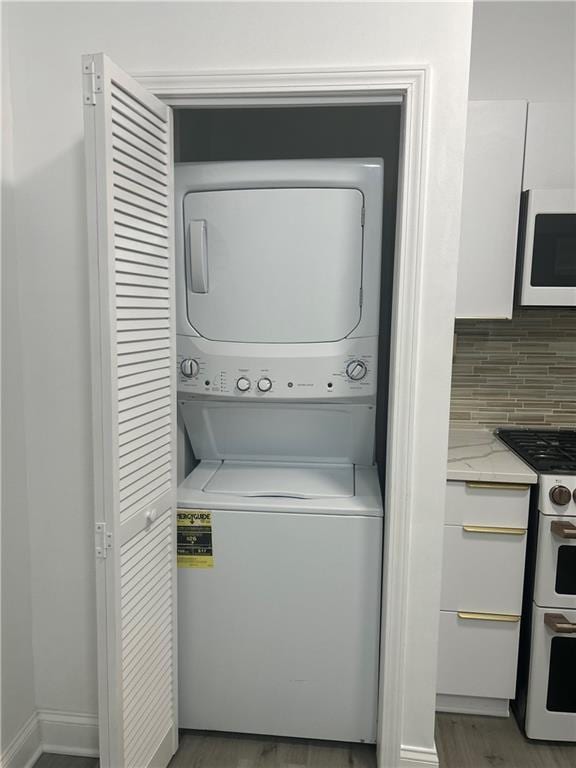 2831 E 8th St, Kansas City, MO 64124 - laundry area with stacked washer / drying machine and light wood finished floors