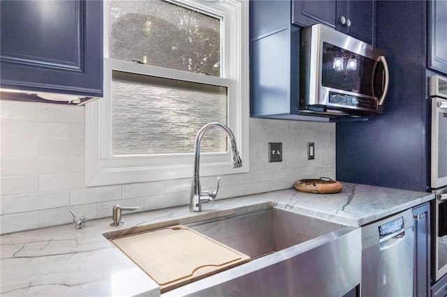 16011 W 149th Ter, Olathe, KS 66062 - kitchen with stainless steel appliances, backsplash, light stone countertops, and blue cabinetry
