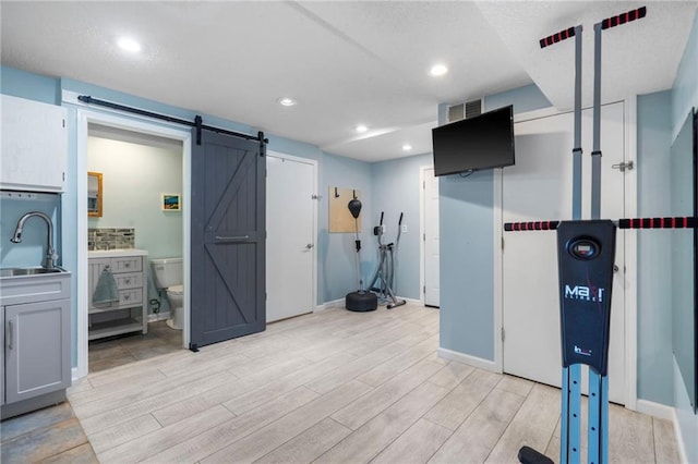 16011 W 149th Ter, Olathe, KS 66062 - workout room with a barn door, light wood-type flooring, and recessed lighting