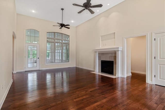 906 Cheatham Ct, Warrensburg, MO 64093 - unfurnished living room with ceiling fan, wood-type flooring, a fireplace, a towering ceiling, and baseboards