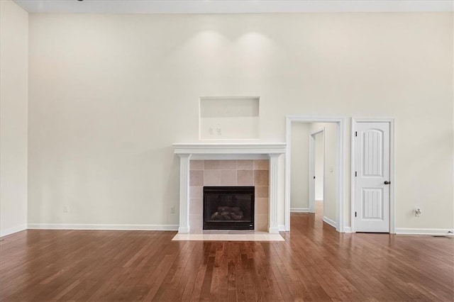 906 Cheatham Ct, Warrensburg, MO 64093 - unfurnished living room with wood finished floors, baseboards, and a tiled fireplace