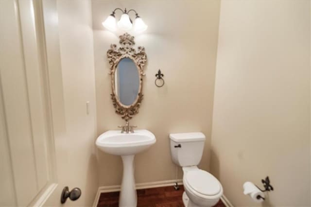 906 Cheatham Ct, Warrensburg, MO 64093 - bathroom with toilet, baseboards, a sink, and wood finished floors