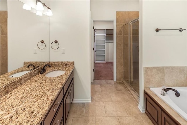 906 Cheatham Ct, Warrensburg, MO 64093 - full bathroom with a stall shower, vanity, a walk in closet, a bath, and baseboards