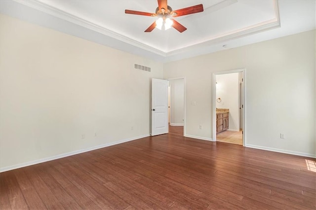 906 Cheatham Ct, Warrensburg, MO 64093 - unfurnished bedroom featuring a tray ceiling, wood finished floors, and baseboards