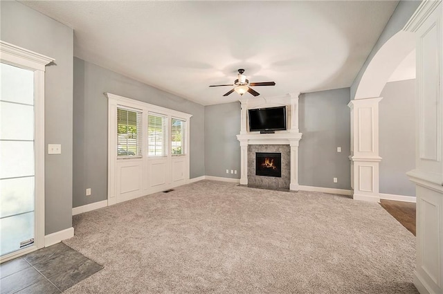 5021 NW Timberline Dr, Riverside, MO 64150 - unfurnished living room with a ceiling fan, a large fireplace, arched walkways, carpet, and baseboards