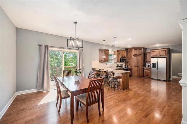 5021 NW Timberline Dr, Riverside, MO 64150 - dining area featuring wood finished floors, baseboards, recessed lighting, and a chandelier