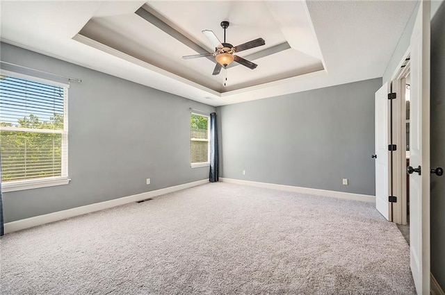 5021 NW Timberline Dr, Riverside, MO 64150 - spare room with a tray ceiling, ceiling fan, carpet, and baseboards