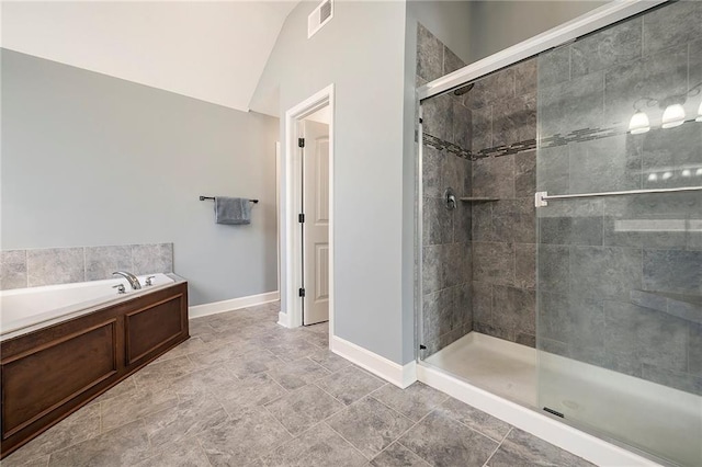 5021 NW Timberline Dr, Riverside, MO 64150 - full bathroom featuring a bath, a stall shower, vaulted ceiling, and baseboards