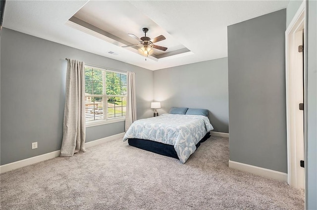 5021 NW Timberline Dr, Riverside, MO 64150 - bedroom with a raised ceiling, carpet, baseboards, and a ceiling fan