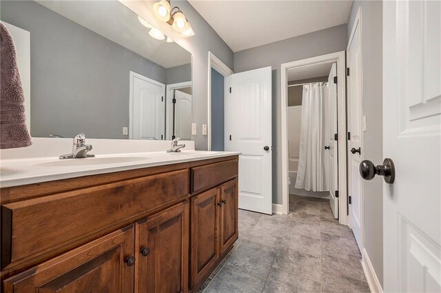 5021 NW Timberline Dr, Riverside, MO 64150 - full bathroom featuring double vanity, baseboards, and shower / bath combo with shower curtain