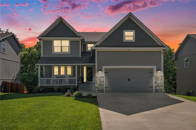5021 NW Timberline Dr, Riverside, MO 64150 - craftsman-style house with a porch, a lawn, concrete driveway, stone siding, and an attached garage
