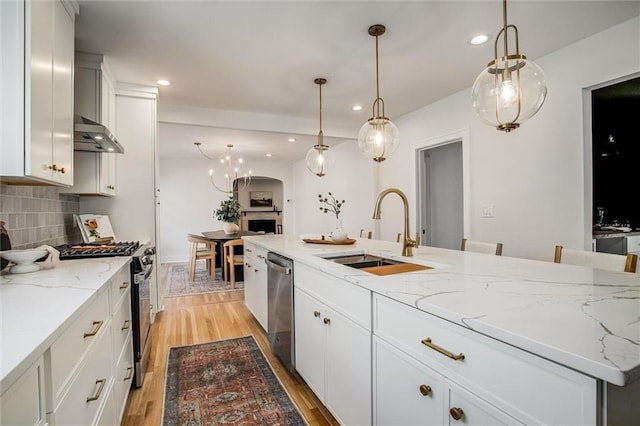 4804 Jarboe St, Kansas City, MO 64112 - kitchen featuring a sink, stainless steel appliances, recessed lighting, light wood finished floors, and decorative backsplash