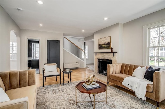 4804 Jarboe St, Kansas City, MO 64112 - living area featuring wood finished floors, stairs, arched walkways, a fireplace, and recessed lighting