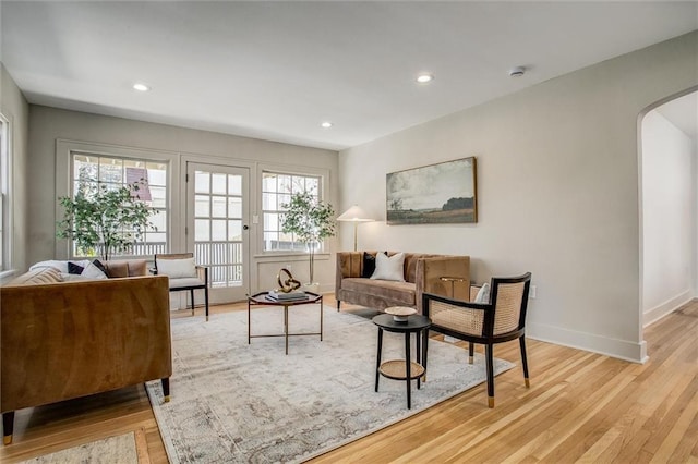 4804 Jarboe St, Kansas City, MO 64112 - living area with arched walkways, light wood finished floors, recessed lighting, and baseboards