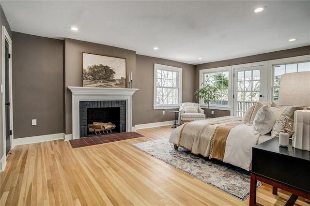 4804 Jarboe St, Kansas City, MO 64112 - bedroom with access to outside, baseboards, wood finished floors, a brick fireplace, and recessed lighting