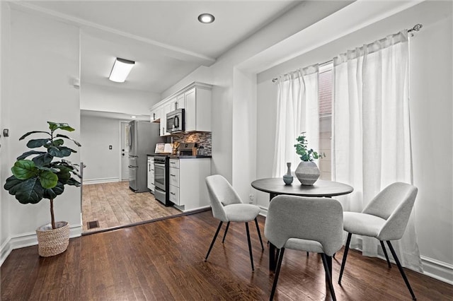 4421 Tracy Ave, Kansas City, MO 64110 - dining room with recessed lighting, wood finished floors, and baseboards