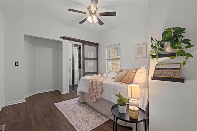 4421 Tracy Ave, Kansas City, MO 64110 - bedroom with a barn door, wood finished floors, access to exterior, and ceiling fan