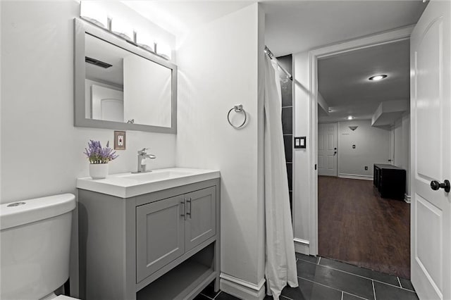 4421 Tracy Ave, Kansas City, MO 64110 - bathroom featuring vanity, toilet, a shower with curtain, tile patterned floors, and baseboards