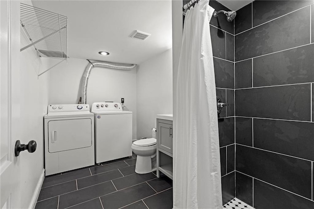 4421 Tracy Ave, Kansas City, MO 64110 - full bath with washer and clothes dryer, a stall shower, tile patterned floors, and toilet