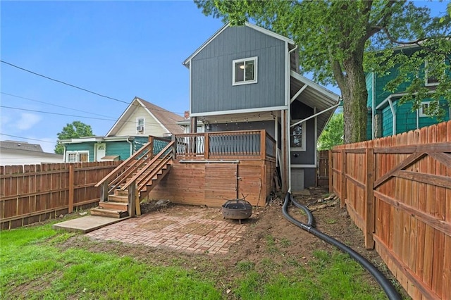4421 Tracy Ave, Kansas City, MO 64110 - rear view of house featuring a fenced backyard, stairway, a fire pit, and a patio